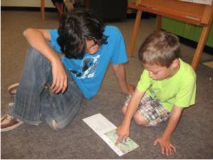 Two boys take turns reading to each other, as detailed in a student blog entry.